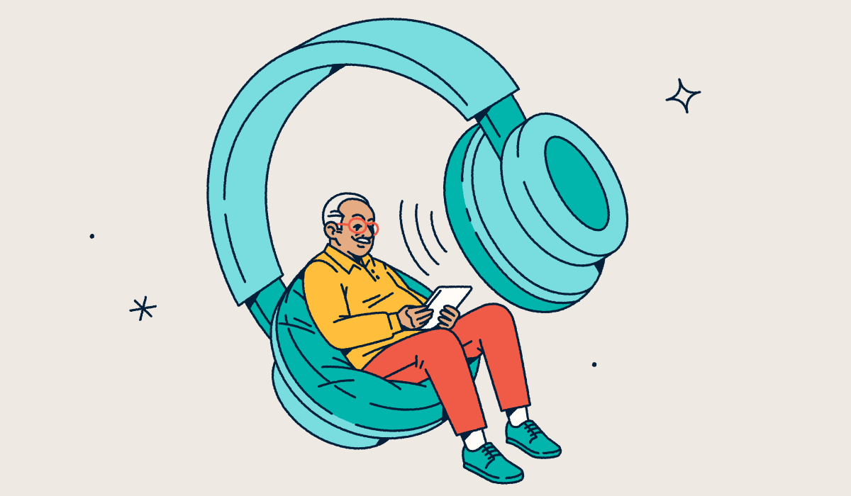 A person looking at a tablet while sitting in one side of a giant pair of headphones.