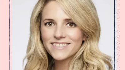 A headshot of a smiling woman with blonde hair.