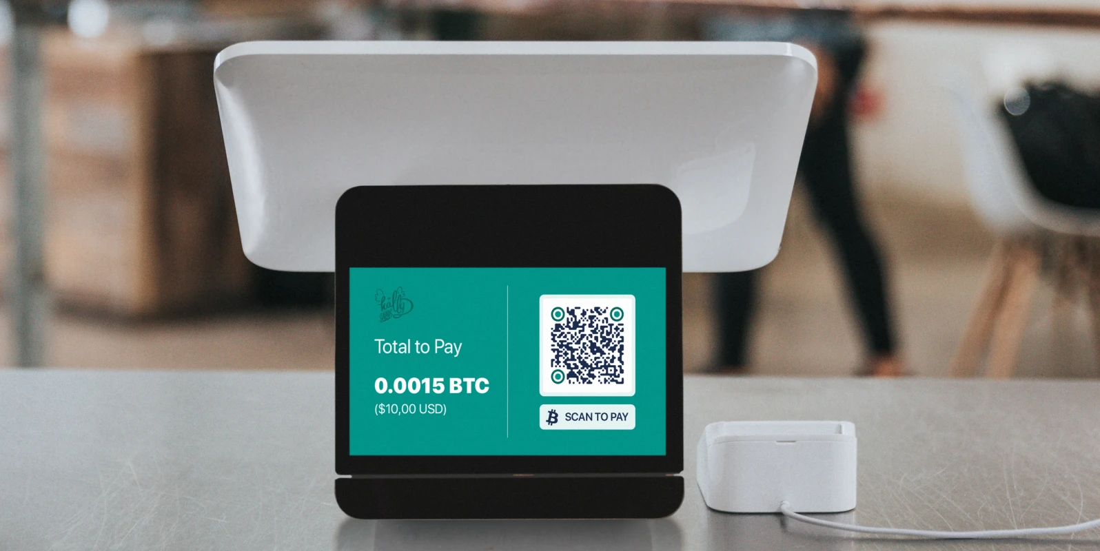 Cash register on a counter with a tablet displaying a payment QR Code.